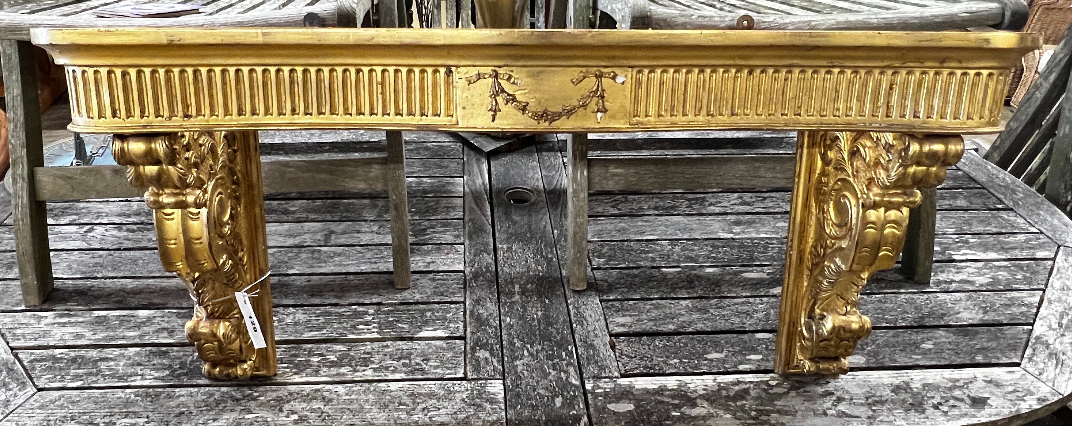 An 18th century style carved giltwood and composition console table (lacks marble top), width 90cm, height 46cm